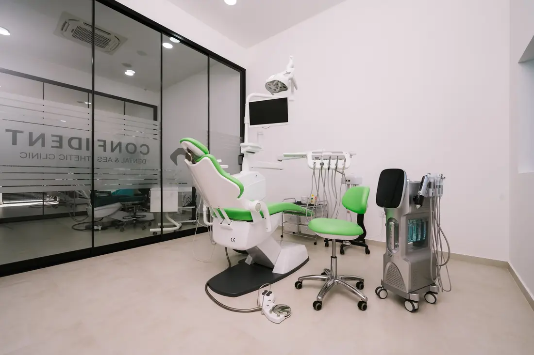 Sala za estetsku medicinu sa zelenom stolicom i profesionalnim aparatom za tretmane lica