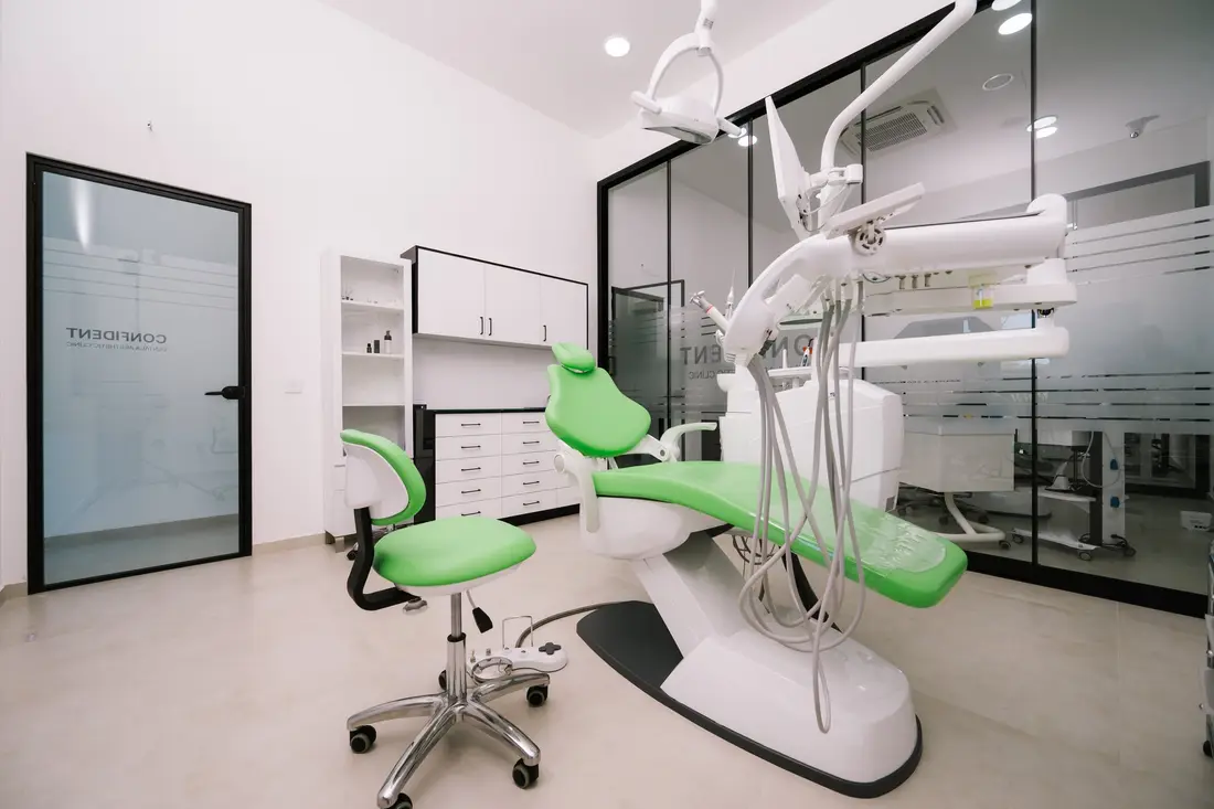 Sala za estetsku medicinu sa zelenom stolicom za tretmane i ormarićima