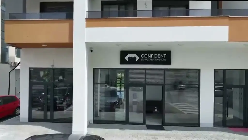 Ulaz u stomatološku i estetsku kliniku Confident na Bulevaru Teuta u Ulcinju, s natpisom klinike iznad staklenih vrata