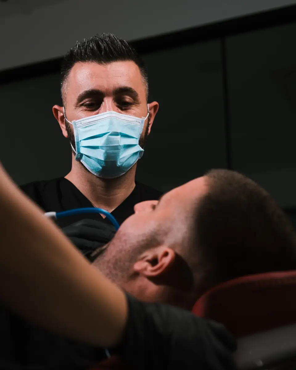 Dr Agron Shabani tretira pacijenta uz pomoć stomatološke asistentkinje